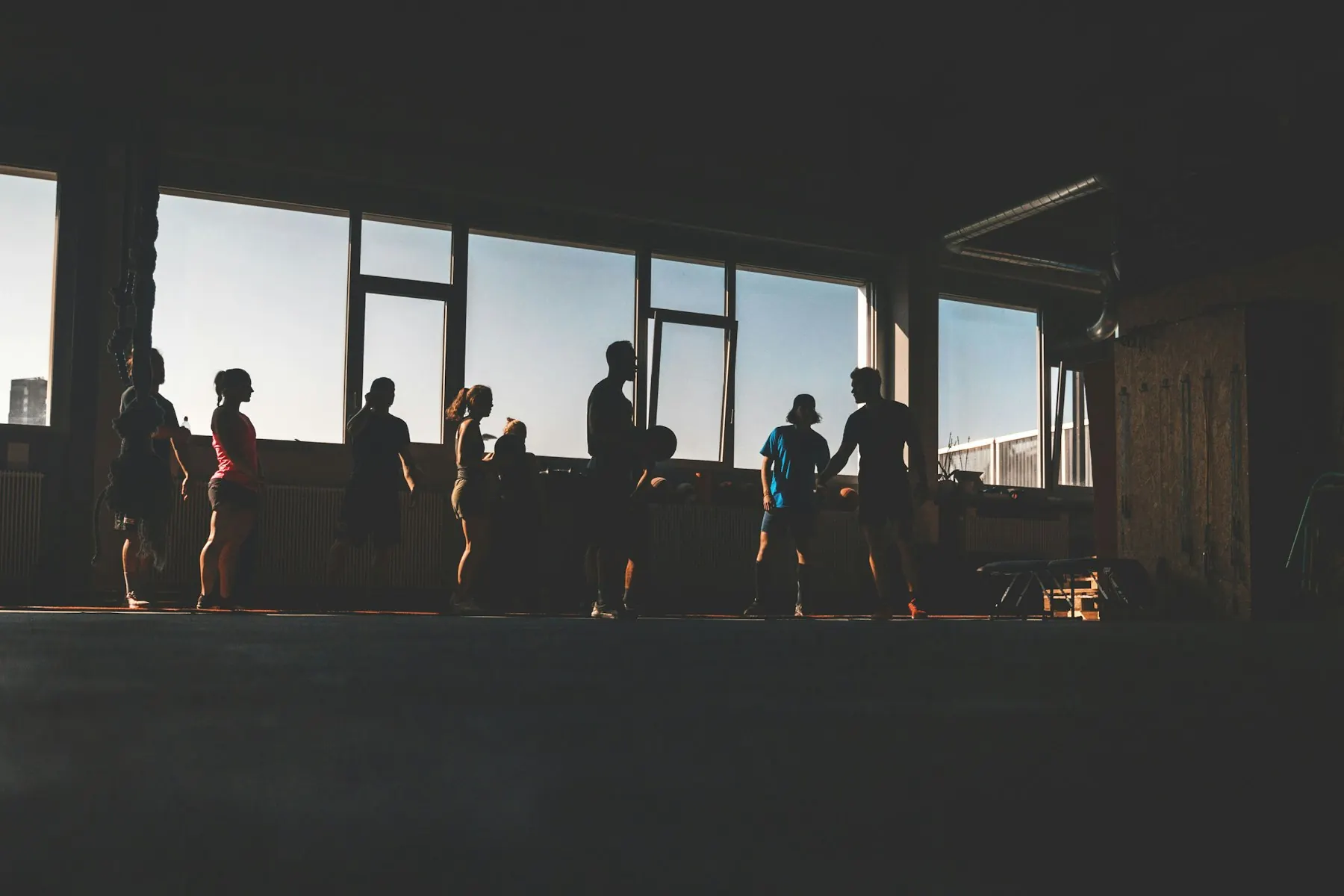 Silhouettes of an early morning class against the gym windows at first light
