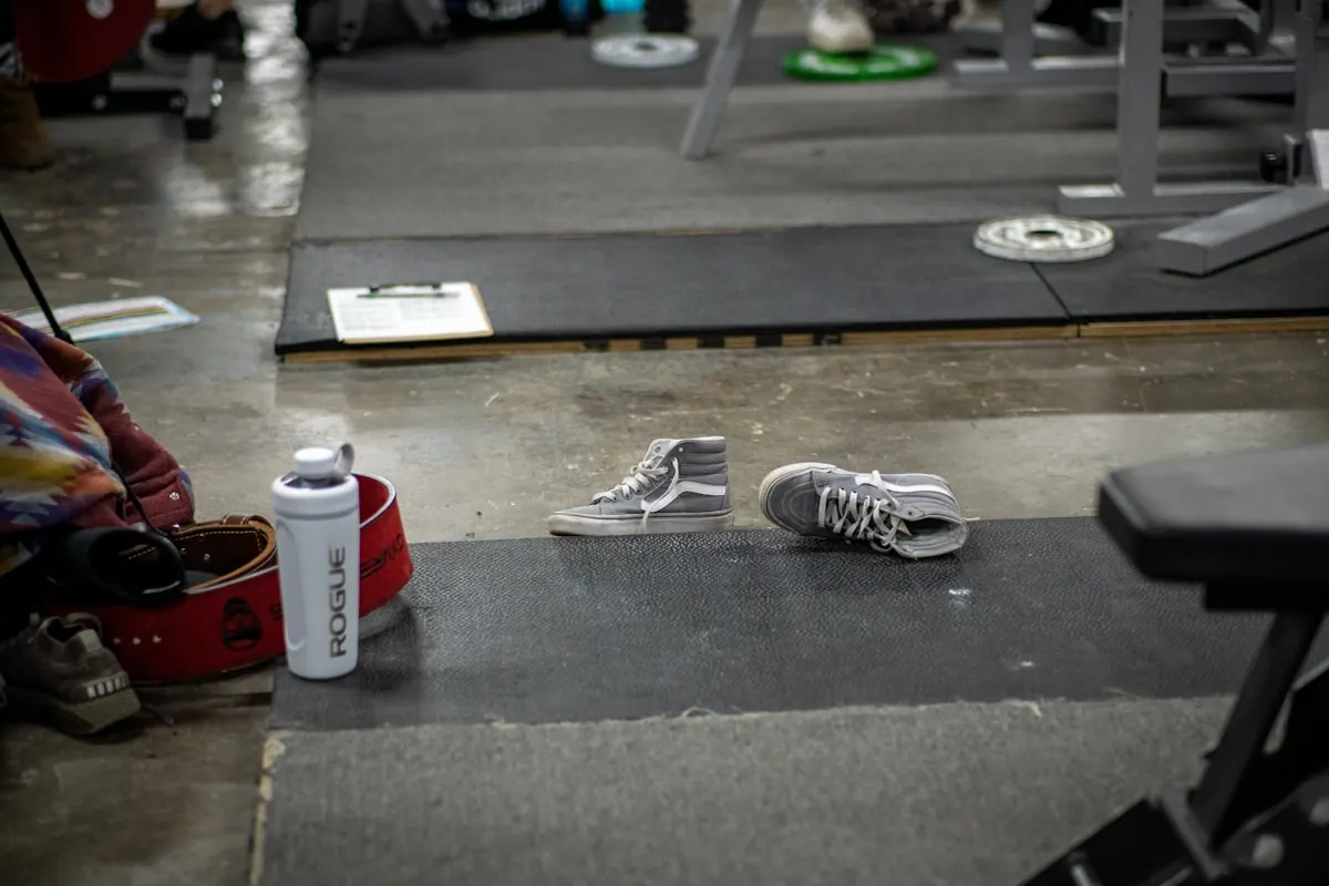 Training shoes and a water bottle on the gym floor before class