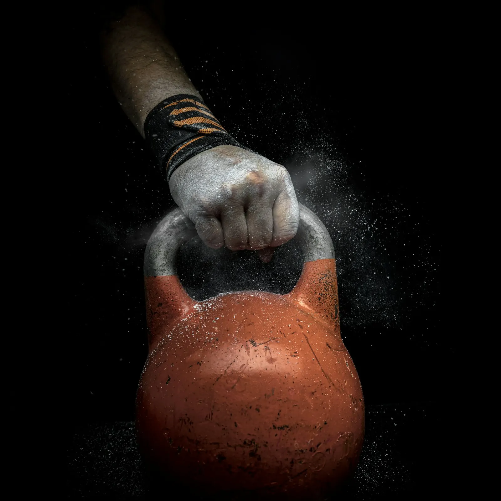 Kettlebell in a burst of chalk dust against black