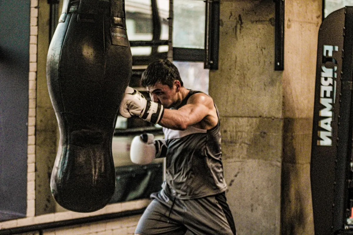 Member throwing a punch at a heavy bag in a dim gym