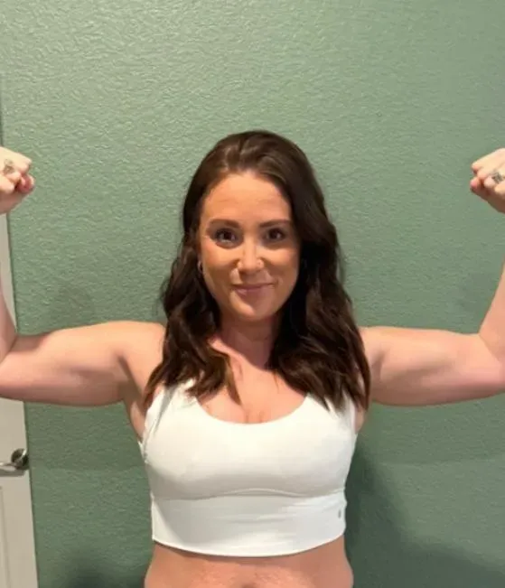Member flexing both arms and grinning