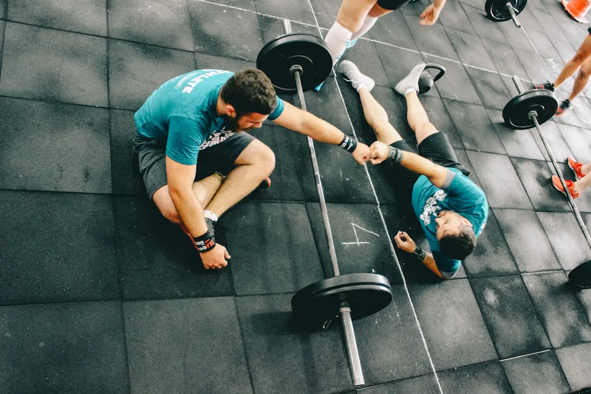 Coach fist bumping a member lying on the floor after a hard set