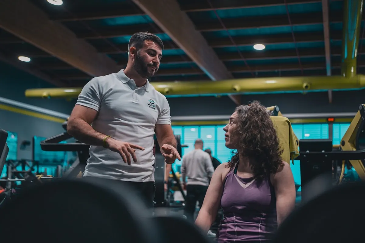 Coach talking through a plan with a member on the gym floor